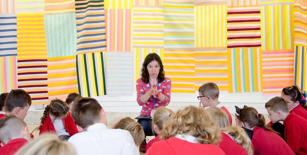 A facilitator talking to a class of school children