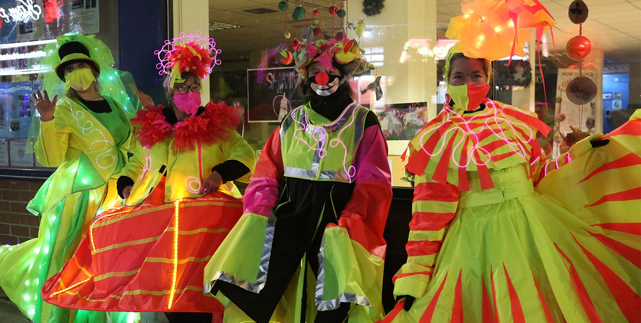Four people in costumes and wearing masks participating in the Whitley Bay carnival