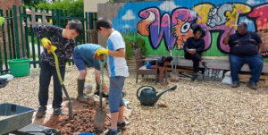 Young people gardening as part of the Hard Times Require Furious Dancing Creative Civic Change project