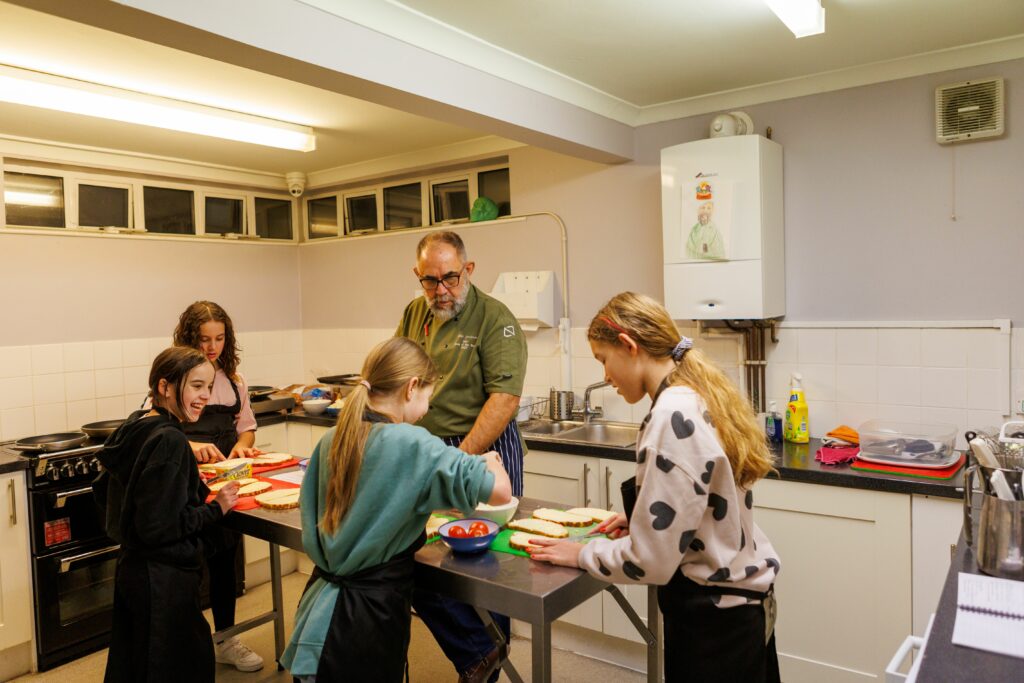 A cooking lesson with four young people at chill club in Newington community centre