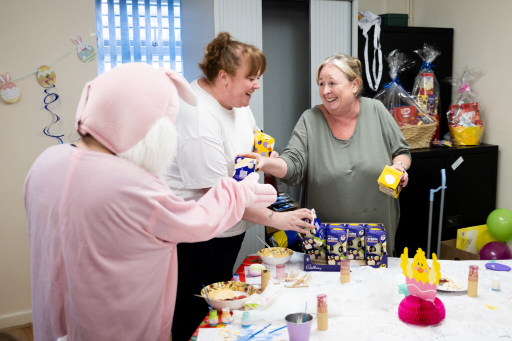 Vicky Williamson and Lisa Cover hand out Easter eggs to someone dressed as the Easter bunny