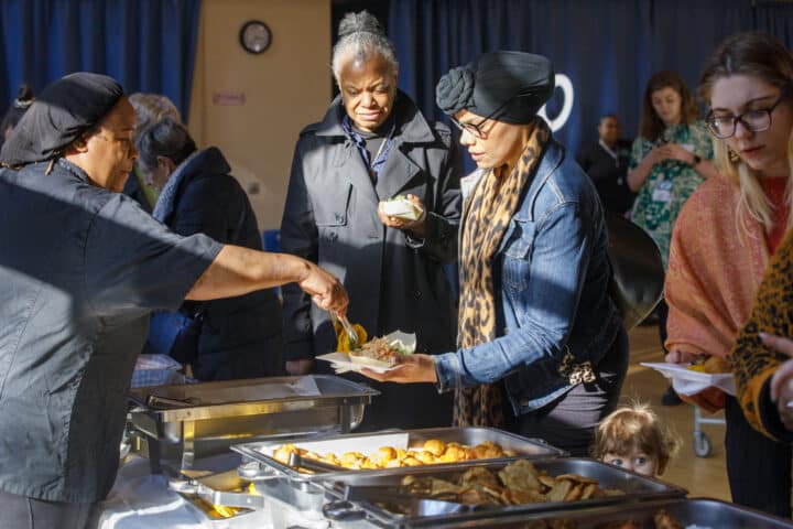 Two women being served food at a community event