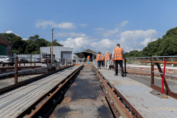 People wearing high vis jackets and walking next to train tracks at the MPower workshop